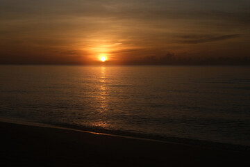 The sun rises at the sea in the morning.