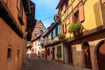 Street with picturesque colorful half-timbered houses in the medieval village of Eguisheim, Alsace, France. Village is ranked in the top 20 of Les Plus Beaux Villages de France. Alsace wine route