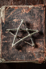 Old ruined book with a pentagram made of sticks