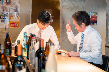 居酒屋で部下の説教をする上司