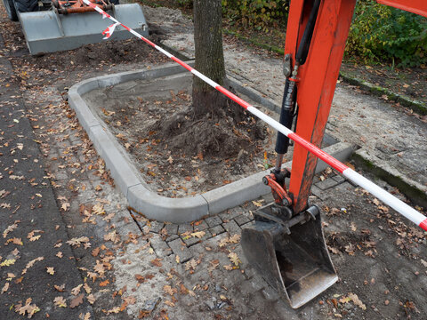 Entsiegelung Baumscheibe - neue Baumgrube mit Einfassung am Stra&szlig;enrand - Radlader und Bagger