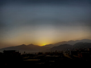 Ocaso en las monta&ntilde;as con cielo dorado y azul