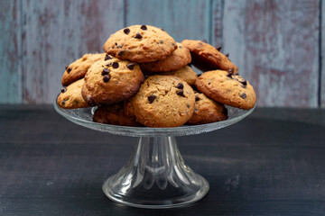 A glass plate with a pile of chocolate chip cookies on it