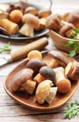 Freshly harvested mushrooms arranged on a wooden table with a knife and garnish ready for culinary preparation