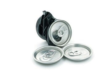 Black cans and caps of soda cans on white background, recycled material concept.
