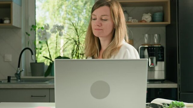 Woman working remotely online at home office, using computer, Freelancer procrastinate at home workplace, spinning on chair