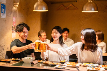 居酒屋でお酒を飲む若い男女