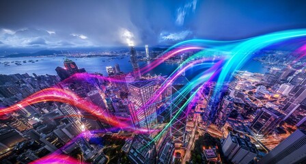 Aerial view of Hong Kong at night with illuminated skyscrapers and colorful streaks of light.