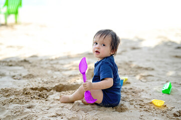 Baby on the beach with toys