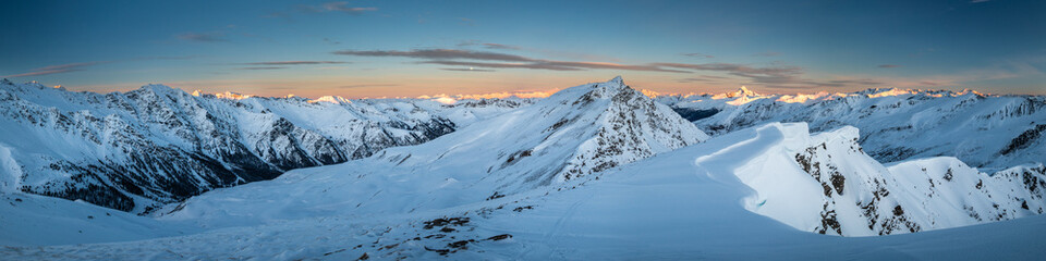 Panoramic view of mountain range at sunrise; mountains covered by snow in Queyras