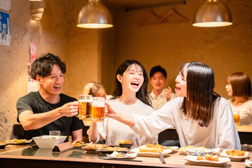 居酒屋でお酒を飲む若い男女