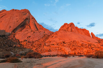 Naklejka premium Der Inselberg Spitzkoppe oder auch das Matterhorn Namibias genannt bei Sonnenuntergang, Erongogebirge in Namibia, Touristenattraktion und Wandermöglichkeiten