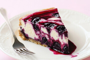 Slice of blueberry cheesecake adorned with berry topping