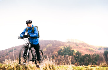 Obraz premium Active man on bike in the middle of beautiful nature, enjoying beautiful view. Concept of healthy lifestyle.
