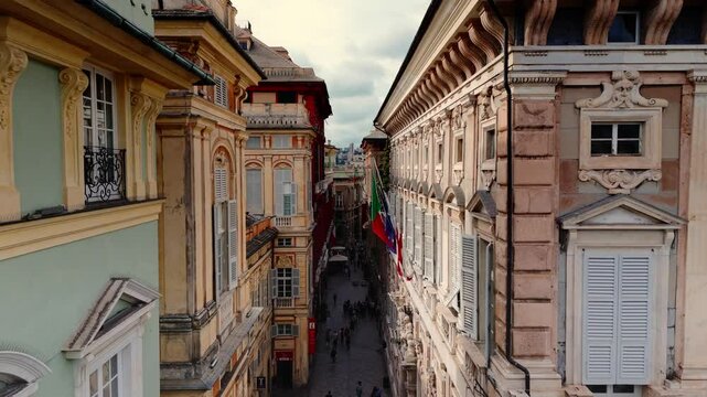 Genoa's historic city center with tourists walking through narrow streets at sunset, aerial view