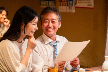 若い女性と二人でお酒を飲む男性