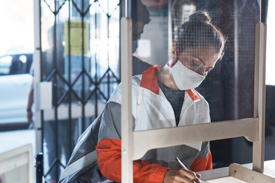 Woman, filling and paperwork at reception with gym registration, face mask compliance and fitness sign up. Girl, writing and clipboard with sport membership, health checklist and policy information - Powered by Adobe