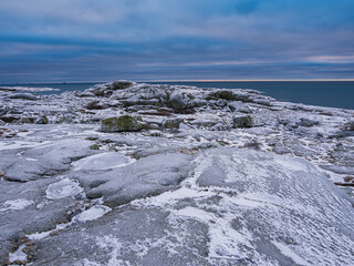 Majestic winter landscape on Höno island, Sweden, showcasing a serene coastal view with snow-covered rocks and calm waters