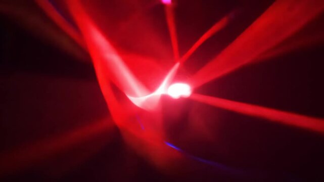 Red glow light rays with time warp on rotate and zoom in effect background. Perspective view of red laser light burst motion. Towards Camera. 4K Video