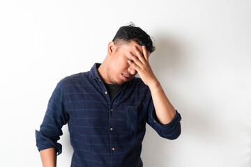 Adult Asian man with head down showing stress expression