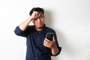 Asian man holding his mobile phone with sad expression