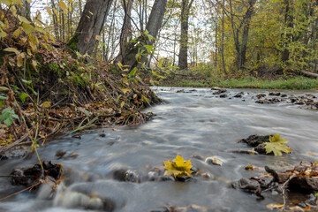 fast river between stones, stream of water passes the stone, ecology in the river, beautiful natural environment as background, blurred stream of water