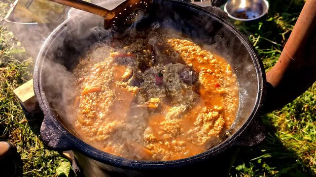 Cooking Delicious Lamb Goulash In Cauldron Outdoor. closeup shot