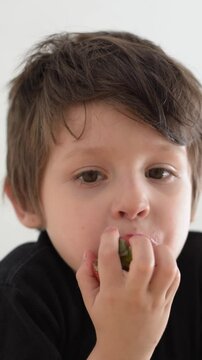 ni&ntilde;o latino comiendo fresas, primer plano de su rostro