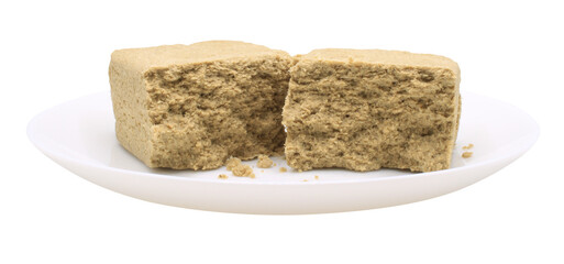 Sunflower halva in a white plate. Side view. Broken halvah pieces. Food isolated on transparent background. Isolate on png format
