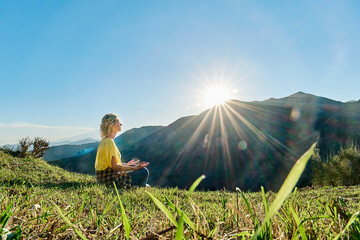 Woman meditating in front of mount Etna on sunny day, Italy