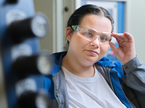 Trainee holding protective eyeglasses at workshop