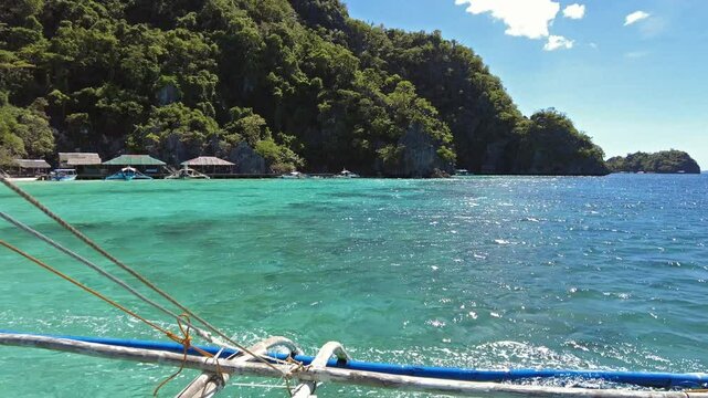 Tropical Philippines island, view from moving boat. White sand beach, rocks cliffs mountains and blue water bay, 4k