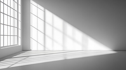 Sunlight streams through a large window in a minimalist room, casting geometric shadows on the white walls and floor.