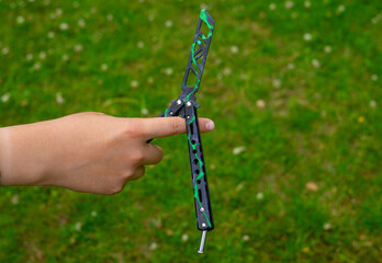 Butterfly knife is a training metal balisong with black elements, held by hand.A safe tool for...