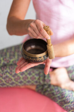 Woman playing rin gong at home