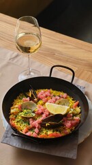 Seafood Paella in a Skillet with a Glass of Wine