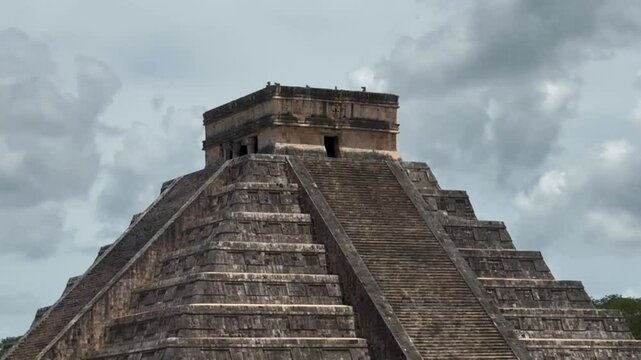 Handheld panning shot revealing the ancient Mayan pyramid of Kukulkan at Chichen Itza in Yucatan, Mexico. 4K