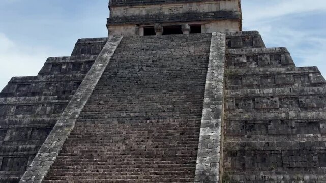 Handheld close-up booming down shot of the steep steps at El Castillo ancient pyramid in Chichen Itza, Mexico. 4K