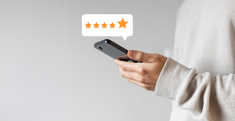 close up on customer man hand pressing on smartphone screen with gold five star rating feedback...