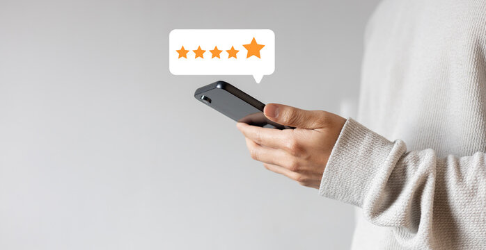 close up on customer man hand pressing on smartphone screen with gold five star rating feedback icon and press level three rank (good) for give score point to review the service business concept