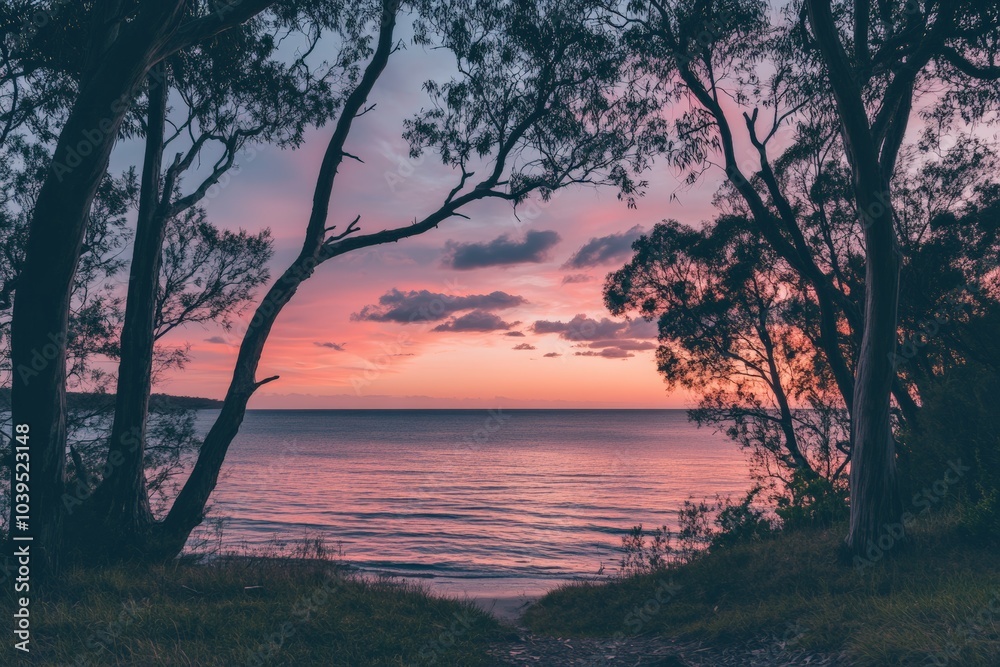Poster a serene view of pastel-colored skies overlooking a calm ocean, framed by silhouetted trees, creatin