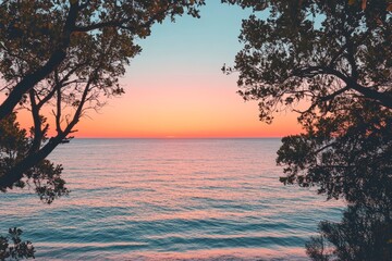 A serene ocean view at dusk framed by lush, vibrant foliage, blending warm orange and calming blue hues that create a tranquil and soothing atmosphere.