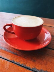 A cup of delicious red coffee, on a wooden table