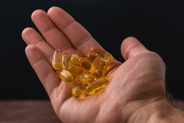 Fototapeta premium A hand holding a bunch of yellow pills