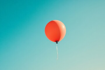 Fototapeta premium A vibrant red balloon ascends into a vast clear blue sky, representing dreams and aspirations. The simplicity of the scene highlights the beauty of freedom.