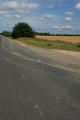 Wide road, highway, sun and blue sky on a summer day.