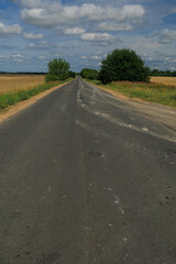 Wide road, highway, sun and blue sky on a summer day.