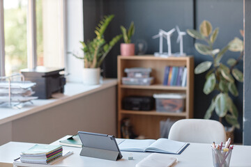 Background image of teachers desk in school classroom with tablet and open notebook on table copy space