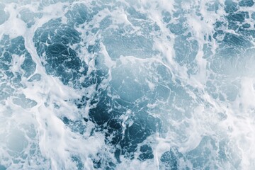 Fototapeta premium A stunning top-down photographic view capturing the swirling, frothy patterns of ocean waves in motion, illustrating the sea's constant, mesmerizing activity and energy.