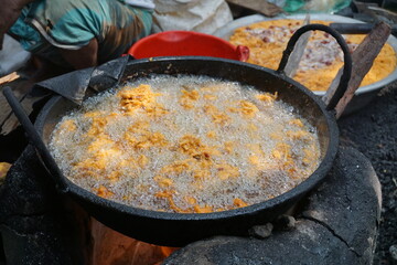 Mix vegetable pakora making and being displayed by a street food vendor, Crispy onion and potato pakoda selling on a market, Spicy veg pakora or pakoda displayed on a rural fair for sale